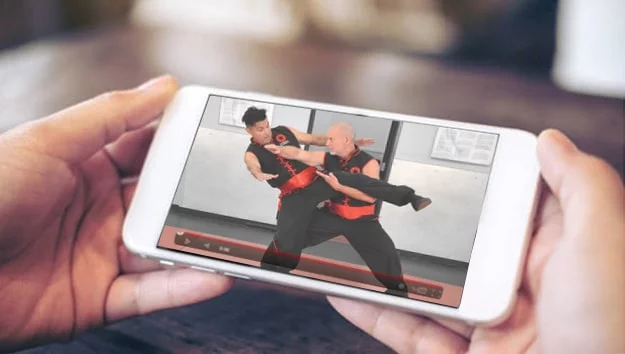 Image of someone accessing Combat Kung-Fu's online self-defense courses from an iPhone.